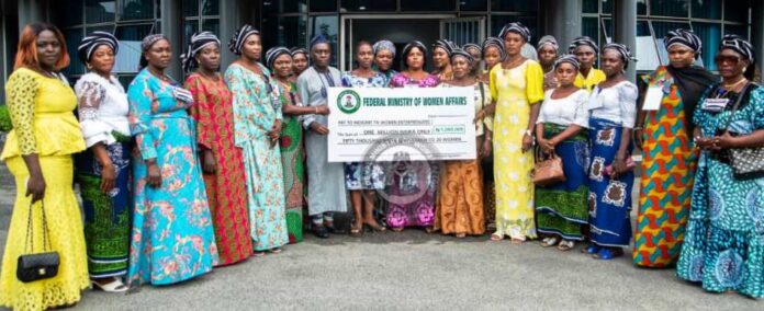 Representative of the Honourable Minister of Women Affairs/Deputy Director, Women Development Department, Mr. Adamu Web in a pose with the beneficiaries at the Presentation