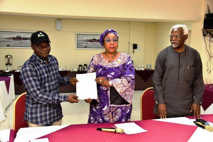 Head of the Civil Service of the Federation, Mrs Didi Esther Walson-Jack, OON,mni( middle), presenting a copy of the signed Memoranda of Understanding(MOU) on Consequential Adjustments in Salaries to the National Chairman,JNPSNC Comrade Benjamin Anthony(L), while the Chairman, National Salaries, Incomes and Wages Commission, Mr Ekpo Nta(R), looks on.