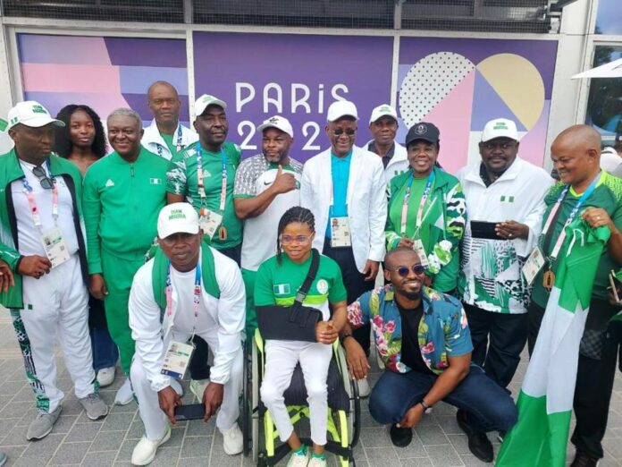 The minister of sports Development , Sen John owan Enoh and the winning Paralympic Team in Paris