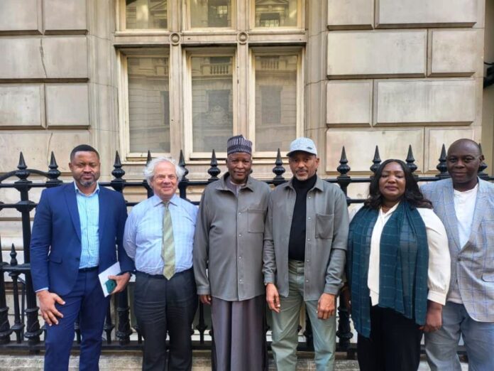 Hon Minister of State, Housing and Urban Development, Abdullahi Tijjani Gwarzo in a group photograph with Jeremy Moody, Secretary and Adviser CAAV and other officials of the Ministry during the meeting