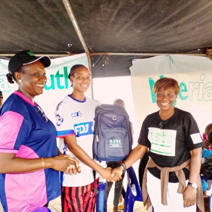 R- L: The Project Manager, Anti-Doping for the National Youth Games and the Chief Executive Officer NADC, Ms. Fadeke Fadeyibi, in a handshake with the Pricer Winner,; Jenifer Ehioziobue of Delta State and NADC Official