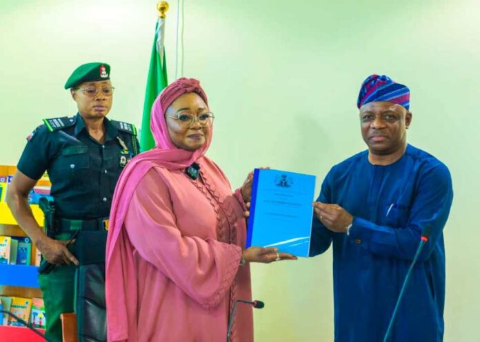 Honourable Minister of Women Affairs, Hajiya Imaan Sulaiman-Ibrahim, fsi, receiving the Hand-Over Notes from Ambassador Gabriel Aduda, the Ministry's Permanent Secretary today, in Abuja