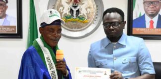 The Honourable Minister, Federal Ministry of Youth Development, Comrade Ayodele Olawande receiving certificate of membership from the National President, NATOMORAS, Ahj. Usman Buba Gwoza, at Abuja.