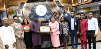 Head of the Civil Service of the Federation, Mrs. Didi Esther Walson-Jack, OON, mni, pose with the symbolic certificate of the Online Compendium of Circulars with members of the technical team.