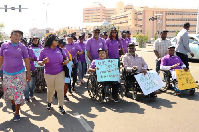 Executive Secretary, National Commission for Persons with Disabilities, Hon. Ayuba Burki Gufwan (right); Representative of the Senior Special Assistant to the President on Special Needs, Onah Chioma Emmanuel (2nd right), with members of staff of the Ministry and others during the roadshow to mark the 2024 International Day of Persons with Disabilities - Abuja