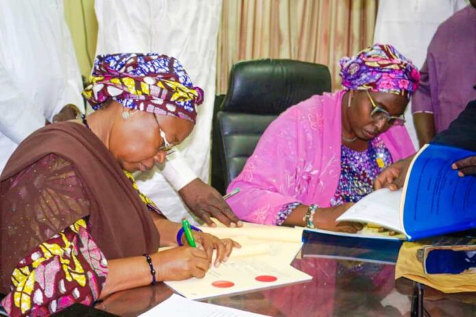 Signing of Memorandum of Understanding between the Federal Government and Adamawa State Government on the handover and conversion of Cottage Hospital Hong and General Hospital Mubi to Federal Medical Centres. L-R: The Deputy Governor of Adamawa State Prof. Kaletapwa Farauta signing the MoU; Permanent Secretary Federal Ministry of Health & Social Welfare Daju Kachollom mni, signs on behalf of the Federal Government.