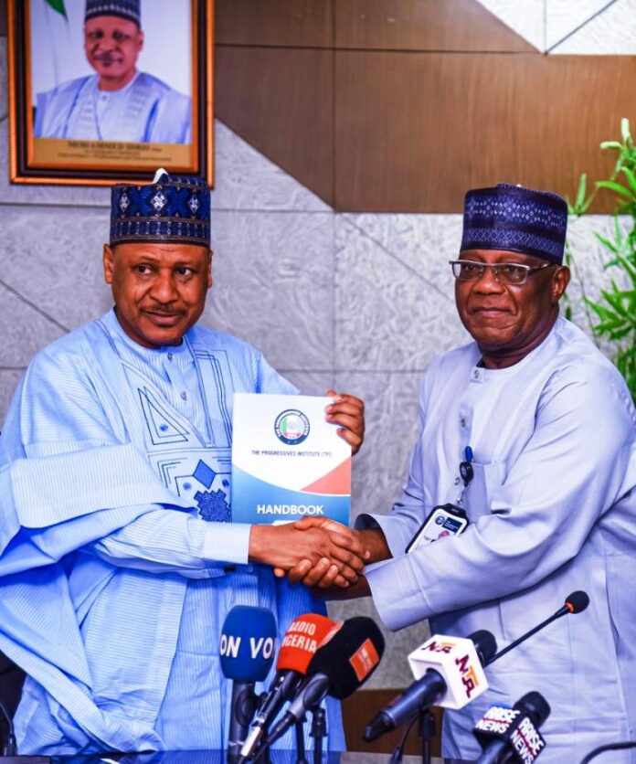 Minister of Information and National Orientation, Mohammed Idris (left) receiving the handbook of the Progressives Institute from the Director General of Progressives Institute, Dr. Lanre Adebayo when the management of the Institute paid a courtesy visit to the Minister on Tuesday in Abuja