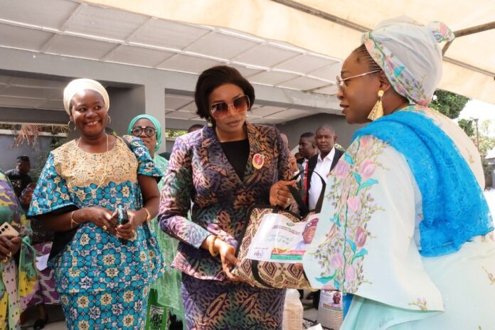 National President, Defence Police Officers Wives Association (DEPOWA), Mrs Oghogho Musa, receiving paliatives from the Honourable Minister of Women Affairs, Hajia Imaan Sulaiman-Ibrahim, on behalf of the Group