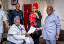 L-R: Executive Secretary NCPWD, Hon. Ayuba Gufwan presenting an appreciation letter to Governor Alex Otti (R) while Her Excellency Mrs Priscillia Otti (M) and Mr David Anyaele, Chairman Commission for the Welfare of the Disabled Persons (behind) looks on