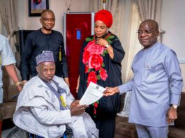 L-R: Executive Secretary NCPWD, Hon. Ayuba Gufwan presenting an appreciation letter to Governor Alex Otti (R) while Her Excellency Mrs Priscillia Otti (M) and Mr David Anyaele, Chairman Commission for the Welfare of the Disabled Persons (behind) looks on