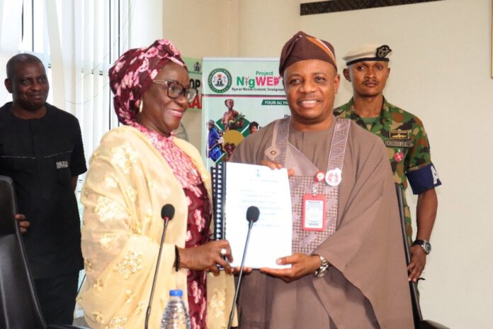 Permanent Secretary, Federal Ministry of Women Affairs, Dr Maryam Ismaila Keshinro receiving the Handing Over Notes from the former PS, FMWA, Amb. Gabriel Aduda during the ceremony held at the Ministry's Hqtrs in Abuja yesterday