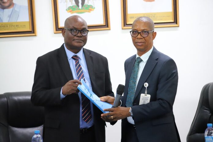 L-R: Permanent Secretary, Ministry of Police Affairs, Dr. Anuma Ogbonnaya Nila receiving hand over note from the Director overseeing the office of the Permanent Secretary, Mr. Okehie Isaac Tochukwu during a meeting with the Management and staff of the Ministry on his assumption of duty at the Ministry of Police Affairs Headquarters in Abuja