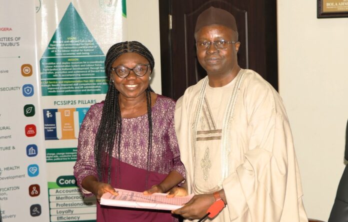 Newly-appointed Permanent Secretary, Labour and Employment, Dr. Salihu A. Usman (right) receiving handover notes from Director, Occupational Safety and Health, Lauretta Adogu, Abuja