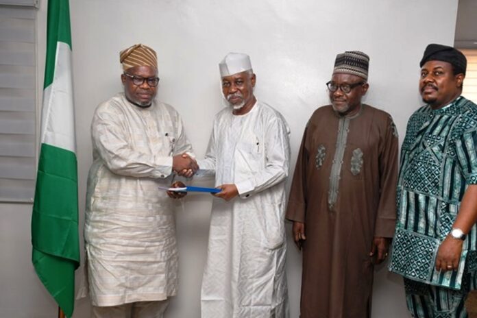 L-R : In a handshake , Surveyor General of the Federation Surv. Abudulganiyu Adeyemi Adebomehin receives the copy of the committee report from the Committee Chairman and Ex Minister of Environment, Surv. Suleiman Hassan Zarma next to him is a member of the committee Surv Umar Nasir and the Registrar of SURCON, Sur. Olugbemiro Olakunle