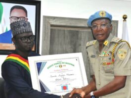 L-R: The Honourable Minister, Federal Ministry of Youth Development, Comrade Ayodele Olawande and the National Commandant of the Peace Corps of Nigeria, Dr Dickson Akoh issuing a certificate of honour to the Minister.