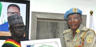 L-R: The Honourable Minister, Federal Ministry of Youth Development, Comrade Ayodele Olawande and the National Commandant of the Peace Corps of Nigeria, Dr Dickson Akoh issuing a certificate of honour to the Minister.