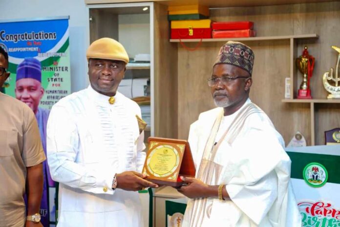 Right, Honourable Minister of State Federal Ministry of Humanitarian Affairs and Poverty Reduction, Dr Yusuf Tanko Sununu, Danmadamin Yauri receiving a Plaque of Honour in recognition of his contributions to humanity and National Development from the National Chairman, Niger Delta People Salvation Front (NDPSF) Alabo Engr Obomate Harry, during a working visit by the group to the Minister of State on Friday 28th February 2025 Federal Secretariat Abuja