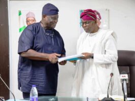 Dr. Iziaq Adekunle Salako Honourable Minister of State for Health & Social Welfare receiving the report of the Committee on Establishment of National Healthcare Facility Regulatory Agency NHFRA; from Dr. Richardson Ajayi Chairman of the Committee.