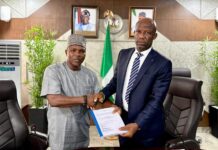 Mr Ogbodo Chinasa Nnam, Permanent Secretary, Federal Ministry of Information and National Orientation (left) receiving hand over documents from Mr Ibidapo Okunnu (right) who oversaw the office, on Monday May 12 2025.