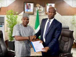 Mr Ogbodo Chinasa Nnam, Permanent Secretary, Federal Ministry of Information and National Orientation (left) receiving hand over documents from Mr Ibidapo Okunnu (right) who oversaw the office, on Monday May 12 2025.