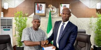 Mr Ogbodo Chinasa Nnam, Permanent Secretary, Federal Ministry of Information and National Orientation (left) receiving hand over documents from Mr Ibidapo Okunnu (right) who oversaw the office, on Monday May 12 2025.