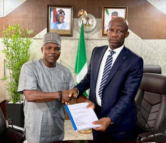 Mr Ogbodo Chinasa Nnam, Permanent Secretary, Federal Ministry of Information and National Orientation (left) receiving hand over documents from Mr Ibidapo Okunnu (right) who oversaw the office, on Monday May 12 2025.