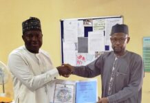 The representative of the Acting Executive Director, NIWRMC, Engineer Shazali Uba Ajingi presenting the Water Use Licence to the Head of Agronomy and Government Relations, Olam Nigeria Ltd, Dr. Umaru Ismaila in his office in Abuja