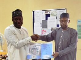 The representative of the Acting Executive Director, NIWRMC, Engineer Shazali Uba Ajingi presenting the Water Use Licence to the Head of Agronomy and Government Relations, Olam Nigeria Ltd, Dr. Umaru Ismaila in his office in Abuja