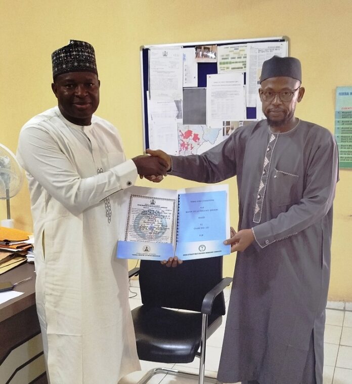 NIWRMC Grants Water Use Licence The representative of the Acting Executive Director, NIWRMC, Engineer Shazali Uba Ajingi presenting the Water Use Licence to the Head of Agronomy and Government Relations, Olam Nigeria Ltd, Dr. Umaru Ismaila in his office in Abuja