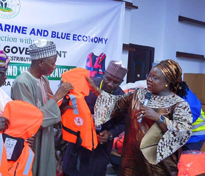 FG Distribute Life Jackets To Kwara State Director, Maritime Services Department, Dr. Mercy Ilori presents the life jacket to the Secretary to the Government, Kwara State, Prof. Mamman Saba Jibril.