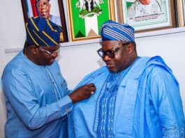 Director General and Chief Executive of the National Space Research and Development Agency Dr. Matthew Adepoju decorating Surveyor General of the Federation Surv. Abudulganiyu Adeyemi Adebomehin with his organisation symbolic lapel pin
