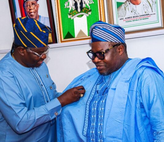 Director General and Chief Executive of the National Space Research and Development Agency Dr. Matthew Adepoju decorating Surveyor General of the Federation Surv. Abudulganiyu Adeyemi Adebomehin with his organisation symbolic lapel pin