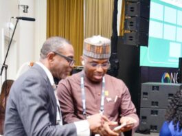 The Permanent Secretary MPR. Dr. Emeka Vitalis Obi mni (right) tutoring a visitor to the MPR's Exhibition Booth about the operationalisation of the Ministry's Scan Code at the 2025 NOG Energy Week in Abuja.