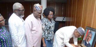 The Permanent Secretary, Ministry of Regional Development, Dr. Mary Ada Ogbe with top management staff look on as, the Honourable Minister, Ministry of Regional Development, Engr. Abubakar Momoh signing the Condolence Register of late former President Muhammadu Buhari, in his office on the 11th floors, Federal Secretariat Phase 1, Abuja.
