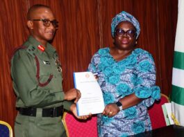 The Representative of the National Coordinator SERVICOM Presidency Office , Mr . Anthony oshin, Mrs Ngozi Akinbodewa presenting the report to the Director General National Youth Service Corps, Brigadier General Olakunle Nafiu, today at the NYSC Headquarters Office, Abuja