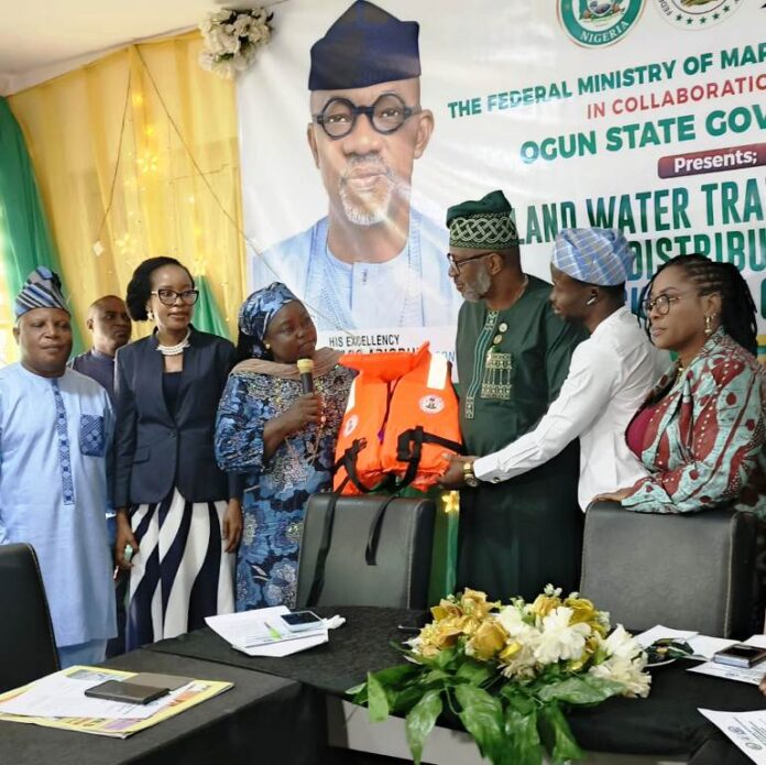 Life Jacket Distribution in Ogun State Director Maritime Services, Federal Ministry of Marine and Blue Economy, Dr. Mercy Ilori (l), presents the life jacket to the Ogun State Commissioner fir Transportation, Engr. Gbenga Dairo at Abeokuta.