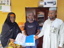 The Acting Executive Director, Nigeria Integrated Water Resources Management Commission (NIWRMC), Mrs. Sakinatu Suleiman Abbo Jimeta (L) making presentation of the Water Use Licence to Engr Leo Morga, Technical Manager, Nigeria Mills, Calabar, (M) flanked by the Director, Allocation and Authorisation, Engr Shazali Uba Ajingi (R) in Abuja.