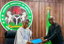 The Honourable Minister of Marine and Blue Economy, His Excellency Adegboyega Oyetola, CON (left) receiving a presentation from the Acting President, Fisheries Cooperative Federation of Nigeria (FCFN), Mr. Mashi Gabriel Sani, at an interactive session with fisheries cooperatives groups in Abuja on Wednesday.