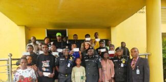CP. Olufemi Abaniwonda in a Group Photograph with Recipients as Some Display their Cheques