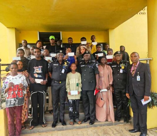 CP. Olufemi Abaniwonda in a Group Photograph with Recipients as Some Display their Cheques