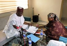 The Executive Director, NIWRMC, Dr. Abdulmumini Muhammed Aminu Zaria receiving the handing over note from the Acting Executive Director, Mrs Sakinatu Suleiman Abbo Jimeta at the Commission