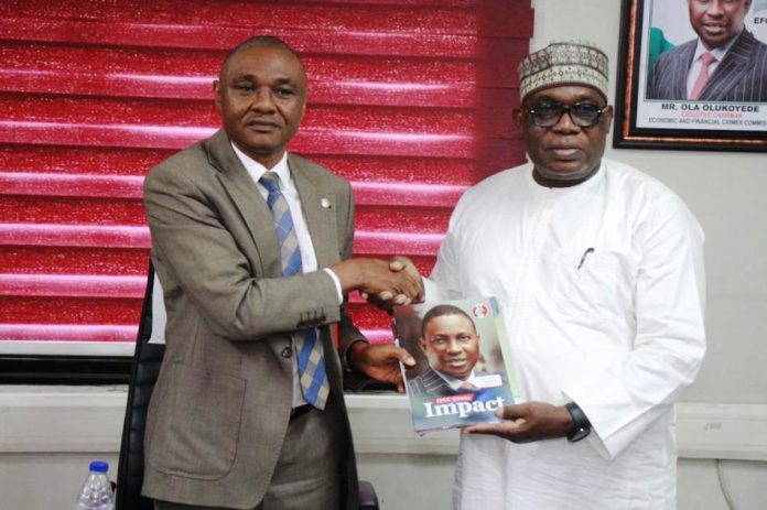 Director-General MCO, Engr. Obadiah Simon Nkom graciously receives a commemorative magazine gift from Ag. Zonal Director EFCC, Asst. Commander Micheal Wetkas during a courtesy visit on Wednesday 3rd September 2025 held at EFCC Zonal Command Office Wuse 2 Abuja.