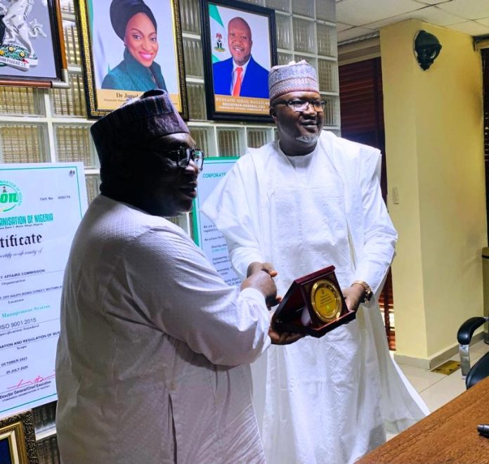 Director-General MCO, Engr. Obadiah Simon Nkom receiving a plaque award presented by the Registrar-General of the Corporate Affairs Commission (CAC), Hussaini Ishaq Magaji, SAN during a courtesy visit by MCO officials to CAC on Tuesday 2nd September 2025, held at CAC headquarter, Abuja.