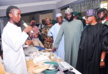 Rep. of the PS, FMIST, Deputy Director, Science Technology and Promotion (STP), Dr. Victor Fadipe (3rd right) Chief Host/Provost, FCT College of Education, Zuba, Dr. Sule Mundi (right) Chairman, House Committee on College of Education, Hon. Adamu Tanko (2nd right) and others with Student of Government Science and Technical College Area 3, Garki, Abuja, at the exhibition stand that Flexible Sanitary Pad from banana trunk waste at the event.