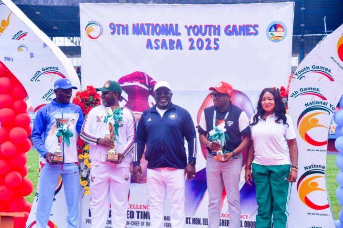 closing ceremony of the Games. R–L: Director, Grassroots Sports Development, Amaka Ashiofu; Commissioner of Sports, Edo State, Mr. Amadin Desmond Enabulele; Governor of Delta State, His Excellency, Rt. Hon. (Elder) Sheriff Oborevwori; Director-General, Lagos State Sports Commission, Mr. Lekan Fatodu; and Chairman, Local Organising Committee, 9th National Youth Games, Asaba, Hon. Onoriode Oborevwori, during the presentation of trophies to winning states at the closing ceremony of the Games.