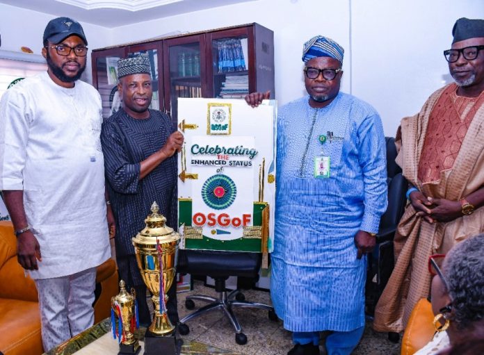 L-R : 2nd from left is Surv Yakubu Najimu Atanda , Chairman NIS (Abuja branch ) presenting their gift to Surveyor General of the Federation Surv. Abuduganiyu Adeyemi Adebomehin during the courtesy visit today