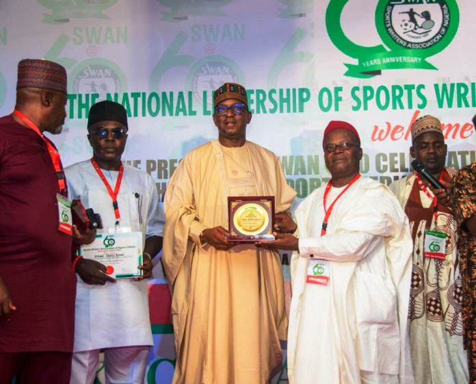 SWAN 60th Anniversary An award is being presented to the Chairman National Sports Commission, Mallam Shehu Dikko, by Chief Donatus Agu Ejioke, for his outstanding supports for the Sports writer Associations of Nigeria, during their 60 years anniversary celebrations at the MKO Abiola Stadium, Abuja