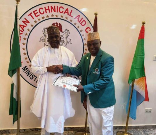 The DG/CEO NTAC pictured presenting the Returnee Volunteer, Prof. Joseph Tanko Apagu (in NTAC Blazers) with the Certificate of Completion