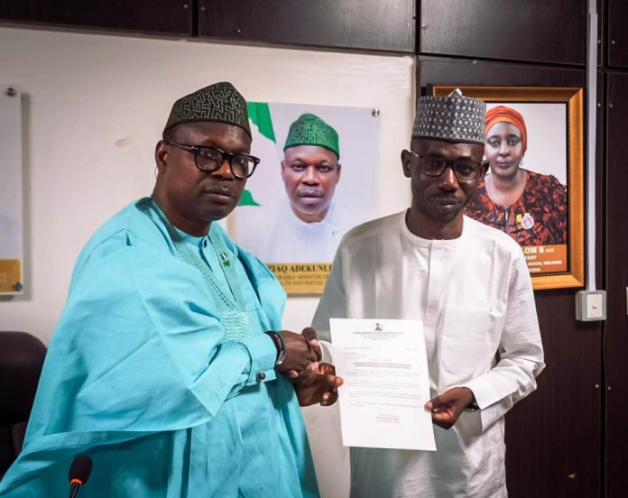 Honorable Minister of State for Health and Social Welfare Dr Iziaq Adekunle Salako, presenting letter of appointment to Dr Idris Garba, the newly appointed Registrar, Radiographers Registration Board of Nigeria
