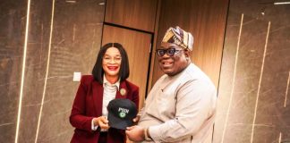 The Honorable Chairman Federal Civil Service Commission Prof Tunji Olaopa receiving a customized face cap from the Administrative CEO Public Service Institute of Nigeria Imeh Okon Esq.